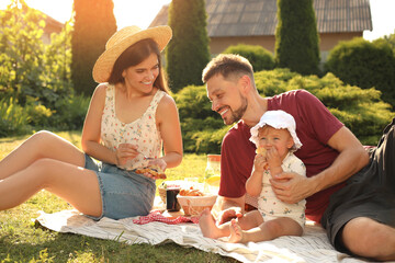 Happy family having picnic in garden on sunny day
