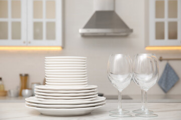 Set of clean dishes and glasses on table in stylish kitchen
