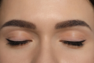 Young woman with permanent makeup of eyes and brows, closeup - obrazy, fototapety, plakaty
