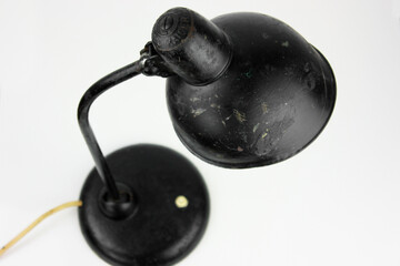 an antique black table lamp from the 20s bauhaus era standing on an old desk commode isolated on...