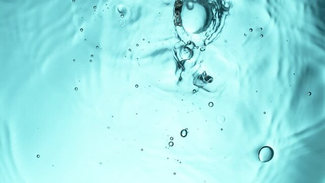 Super slow motion of water drops falling on light blue background. Filmed on high speed cinema camera, 1000 fps.