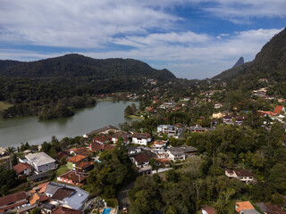 Fototapeta na wymiar Aerial view of Granja Comary, Carlos Guinle neighborhood in the city of Teresópolis. Mountain region of Rio de Janeiro, Brazil. Drone photo. Houses, lake and hills and mountains