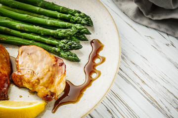 boiled green asparagus and grilled chicken on a white wooden rustic background © Narsil