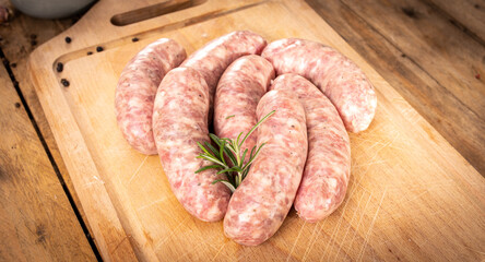 Traditional Polish raw white sausage on a wooden cutting board. Rustic composition with Easter delicacy meat product. 