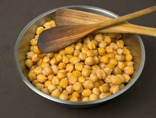 Chickpeas. Metal bowl with cooked chickpeas and two wooden cutlery
