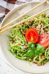 zucchini noodles with quinoa on a white background