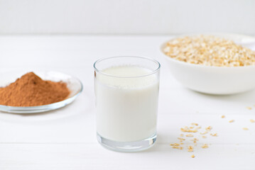 glass of milk oats granola and chocolate on a plate. White background. healthy food. diet.