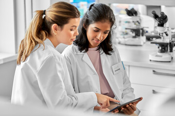 science research, work and people concept - international female scientists with tablet pc computer...