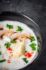 creamy mushroom soup with champignons on a black background