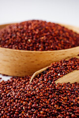 red quinoa seeds on a white acrylic background
