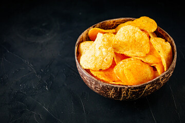 golden crispy potato chips on a dark background