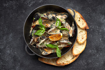 Mussels in a cream sauce with croutons in a pan
