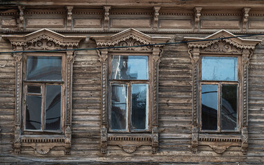 Fototapeta na wymiar Ancient facade of a wooden house. Typical Russian architecture.
