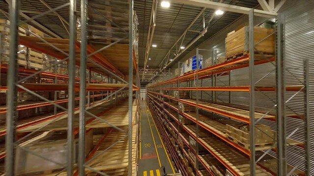 Large shelving units with products in plant storehouse first point view. Industrial complex warehouse interior