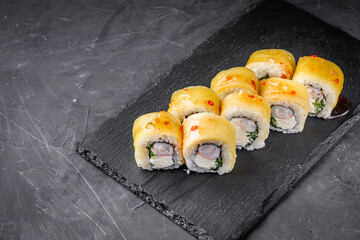 delicious sushi rolls on a black stone background