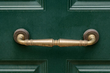 Obraz premium Metal brass vintage old doorknob on wooden green door