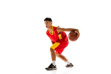 Portrait of young man, basketball player in red uniform training isolated over white studio background. Dribbling