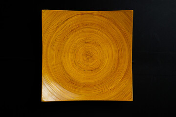 square wooden plate with concentric circles pattern.