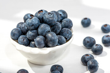 Freshly picked blueberries in a white vintage ceramic bowl. Selective focus.