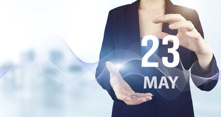 May 23rd. Day 23 of month, Calendar date. Hand hold virtual hologram calendar date with digital wave.  Spring month, day of the year concept.