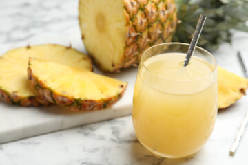 Delicious fresh pineapple juice on white marble table