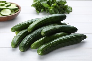Fresh ripe cucumbers on white wooden table