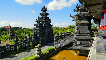 Blick vom Nationaldenkmal in Bali zur Befreiung von Holland auf Steinskulpturen und Park bei blauem Himmel