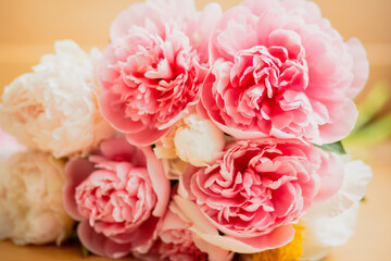 Bouquet of pink and white peonies lying on the table