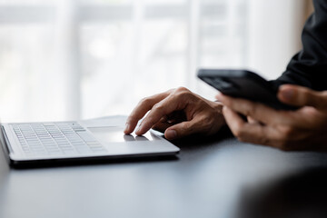 A business man is checking company financial documents and using a laptop to talk to the chief financial officer through a messaging program. Concept of company financial management.