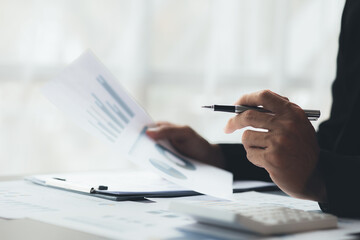 Business men are looking at the company's financial documents to analyze problems and find solutions before bringing the information to a meeting with a partner. Financial concept.
