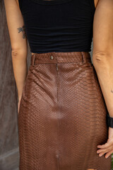 Street style outfit. Woman wearing brown leather skirt