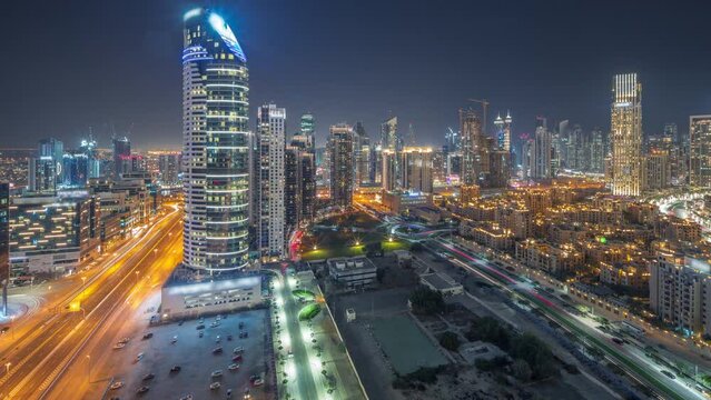 Panoramic view to Dubai's business bay towers aerial day to night transition timelapse. Rooftop view of some skyscrapers and new buildings under construction after sunset