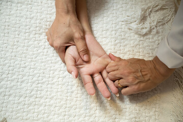 Close up de mãos de massagista aplicando massagem terapêutica na mão de um paciente.