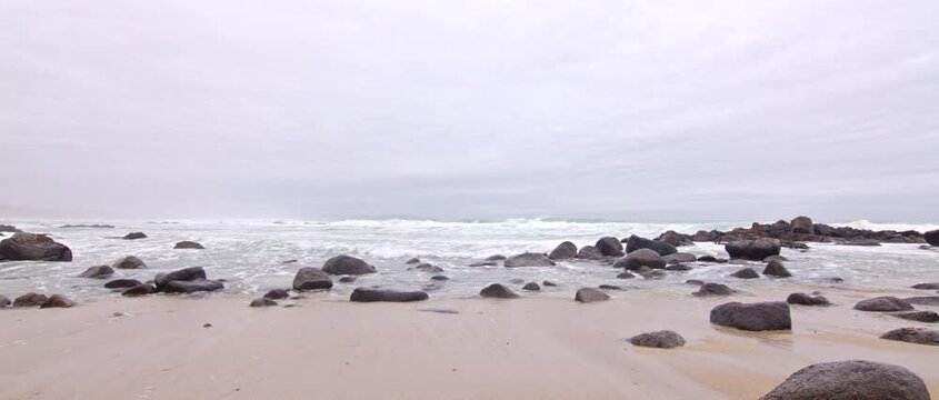 oleaje fuerte en la playa en pleno invierno, playa rocosa dia nublado, website background, b-roll footage, Metraje video cinematográfico