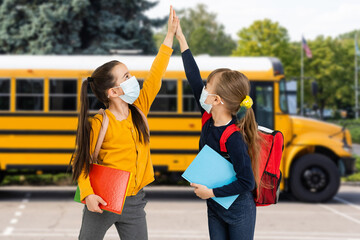Children wearing face protective mask going back to school during corona virus pandemic. Healthcare and education concept