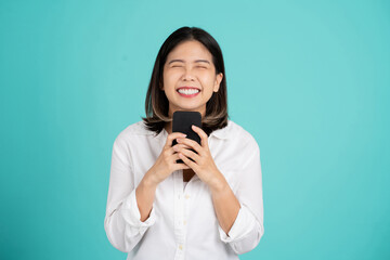Smiling cheerful young asian woman wearing a white shirt standing isolated on bright green background. She looking camera, studio portrait
