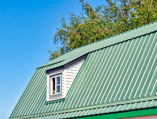 The window on green roof of a farm barn