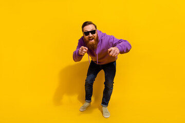 Fototapeta na wymiar Full length photo of cheerful funky man wear violet sweatshirt dark glasses dancing pointing fingers you isolated yellow color background
