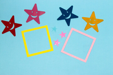 yellow and pink frame as copy space on blue background, colorful stars around
