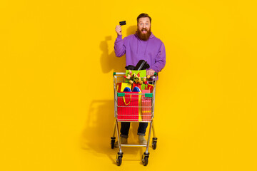 Full length portrait of cheerful excited person hand hold debit plastic card buy holiday gifts...