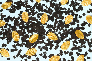 blue background with shredded black paper and gold leaves, creative art modern design
