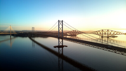 Aerial drone sunrise view of The Queensferry Crossing bridges over the Firth of Forth, Edinburgh,...