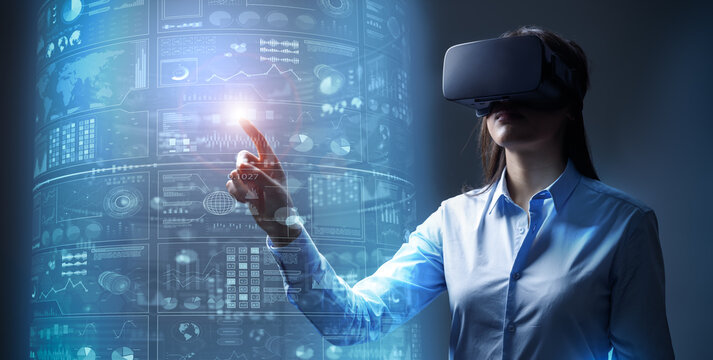 Young Business Woman Wearing Blue Shirt And VR Headset Touching A Virtual Screen. AR And VR Applications In Financial Industry. 