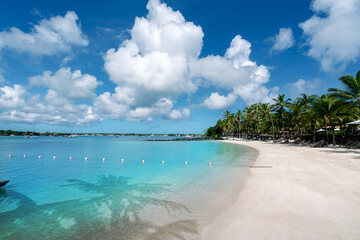 Wide view of the beach and blue water in the summertime in Grand Baie in Mauritius island.