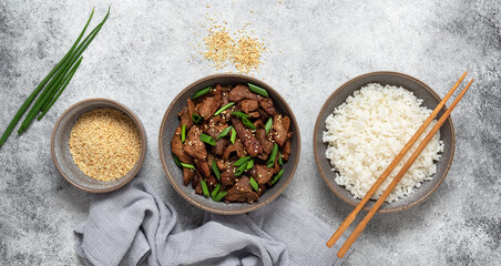 Bulgogi with fried pork and rice. Traditional Korean food. Gray grunge background. Top view, flat...