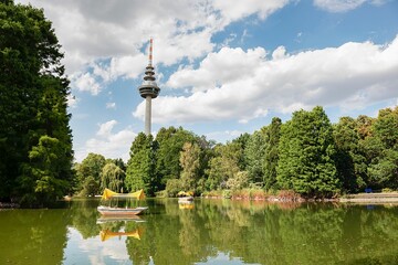 Telecommunications Tower in the Luisenpark park in Mannheim, Germany, with a pond and trees - obrazy, fototapety, plakaty