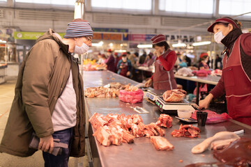 Adult man buying fresh meat at butchery market. Food shopping concept.
