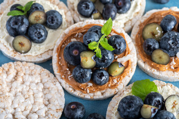 Open sandwich with blueberries. Made from rice crispbreads and peanut butter, healthy nutritious snack option, vegan food