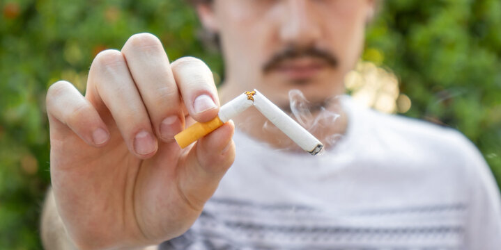Young man breaks the cigarette with his hands . boy quit smoking and stop smoke