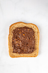 Slice of open sandwiche from wholegrain bread with chocolate crunchy almond butter, healthy snack option